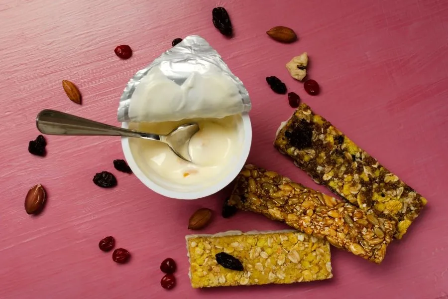 Protein yogurts and bars on a red table